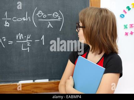 L'école rationnelle girl des formules mathématiques on chalkboard Banque D'Images