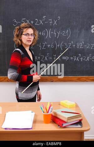 Professeur de mathématiques de graves polynômes expliquant écrit sur tableau noir Banque D'Images