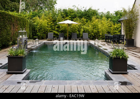 Piscine extérieure avec terrasse en bois et chaises longues Banque D'Images