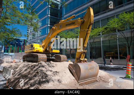 Excavatrice Komatsu garé sur un tas de sable dans le centre-ville de Montréal, province de Québec, Canada. Banque D'Images