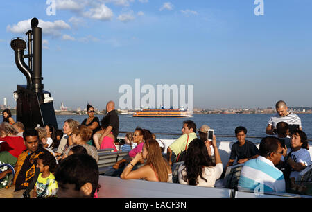 Les touristes en bateau en direction de la Statue de la liberté New York Harbor Banque D'Images