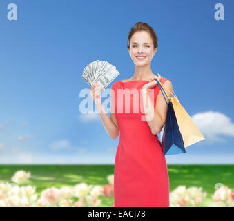 Smiling woman in red dress with shopping bags Banque D'Images