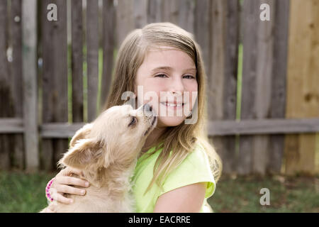 Kid girl blonde avec chihuahua chien kiss jouer heureux outdoor Banque D'Images