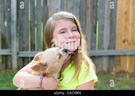 Kid girl blonde avec chihuahua chien kiss jouer heureux outdoor Banque D'Images