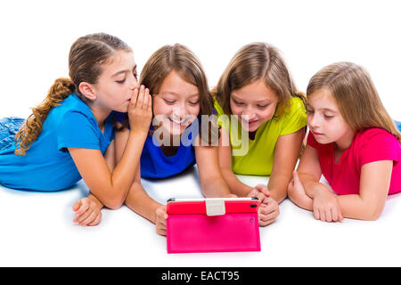 Sœurs cousins kid filles avec tech tablette pc jouer heureux couché sur fond blanc Banque D'Images