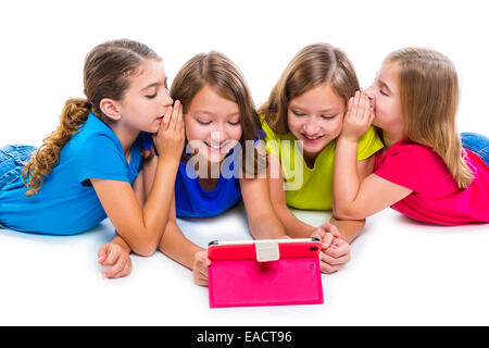 Sœurs cousins kid filles avec tech tablette pc jouer heureux couché sur fond blanc Banque D'Images