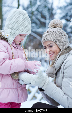 La mère et l'enfant à jouer ensemble dans la neige d'hiver Banque D'Images