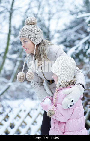 La mère et l'enfant formant un ensemble de boules de neige en hiver Banque D'Images