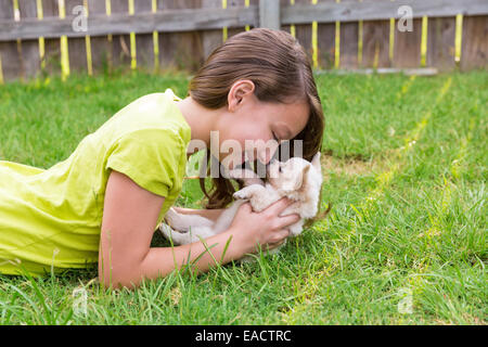 Kid girl and puppy dog heureux jouant avec chiuahua animal couché dans pelouse arrière Banque D'Images