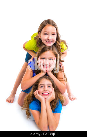 Trois filles enfants heureux amis empilés dans une rangée portrait sur fond blanc Banque D'Images