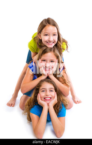 Trois filles enfants heureux amis empilés dans une rangée portrait sur fond blanc Banque D'Images