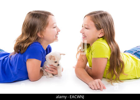 Heureux soeur jumelle kid filles et petit chien couché jouant sur fond blanc Banque D'Images