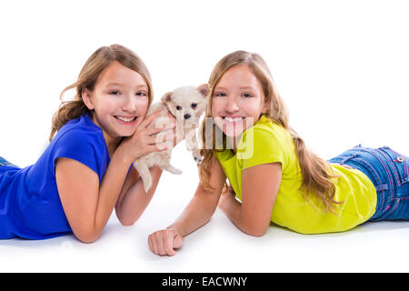 Heureux soeur jumelle kid filles et petit chien couché jouant sur fond blanc Banque D'Images