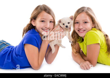 Heureux soeur jumelle kid filles et petit chien couché jouant sur fond blanc Banque D'Images