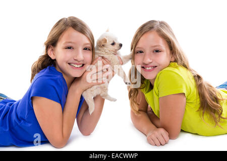 Heureux soeur jumelle kid filles et petit chien couché jouant sur fond blanc Banque D'Images