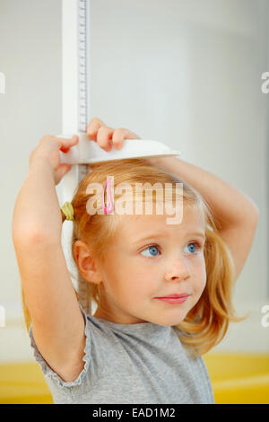 Portrait de petite fille la mesure elle-même. Banque D'Images