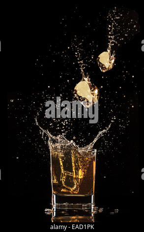 Shot de whiskey isolé avec splash sur fond noir Banque D'Images