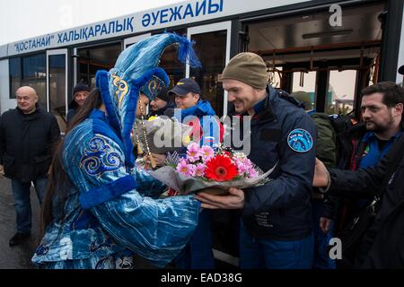 Une femme en robe de cérémonie fleurs Kazakh présente à l'équipage Expédition 41 membre d'équipage Alexander Gerst de l'Agence spatiale européenne lors d'une cérémonie d'accueil à l'aéroport Kustanay 10 Novembre, 2014 dans Kustanay, au Kazakhstan. Suraev, Wiseman et Gerst est revenu sur Terre après plus de cinq mois à bord de la Station spatiale internationale où ils ont servi en tant que membres de l'Expédition 40 et 41 équipes. Banque D'Images