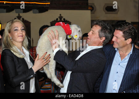 Henndorf près de Salzbourg, Autriche. 11 novembre, 2014. L'acteur britannique Hugh Grant est titulaire d'un agneau sur Novembre 11, 2014 à l'ouverture du marché de Noël à Aiderbichl Estate à Henndorf près de Salzbourg, Autriche. À gauche Kathrin Glock, épouse de l'armurier Gaston Glock et à droite l'acteur Francis Fulton Smith. Dpa : Crédit photo alliance/Alamy Live News Banque D'Images