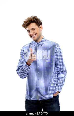 Smiling young man pointing at camera sur fond blanc Banque D'Images
