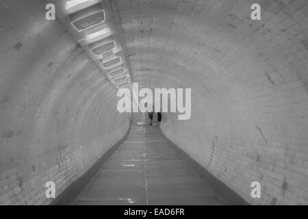 Homme marchant par Greenwich foot tunnel qui passe sous la Tamise entre Greenwich et Isle of Dogs London Banque D'Images