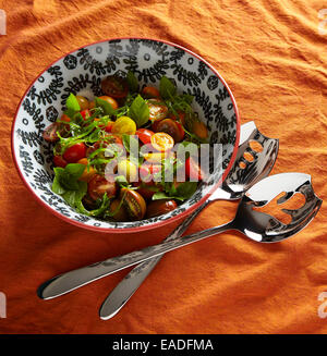 Mélanger la tomate, basilic & Salade d'algues sur une nappe orange de la nourriture dans un bol blanc et noir Banque D'Images