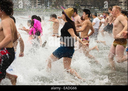 Les personnes en cours d'exécution dans l'eau de la baie English à Vancouver le polar bear swim. Banque D'Images