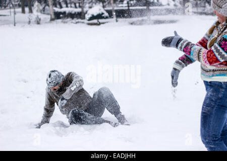 Jeune couple hipster recouverts de neige en plein milieu d'une bataille de boules de Banque D'Images