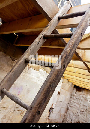 Détail de l'échelle en bois menant à un toit en bois poutres apparentes sur un chantier Banque D'Images