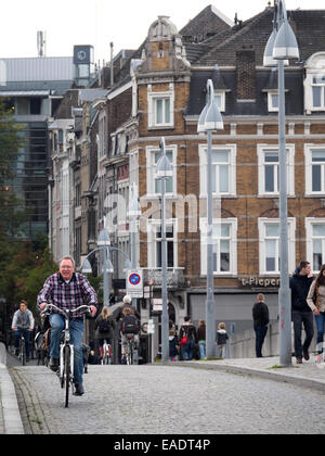 Vieil homme équitation son vélo dans une rue pavée à Maastricht, aux Pays-Bas, en Europe Banque D'Images