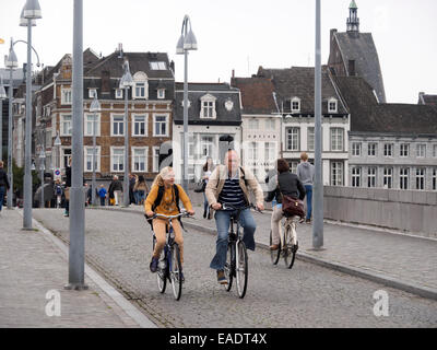 Les gens la bicyclette dans une rue pavée à Maastricht, aux Pays-Bas, en Europe Banque D'Images