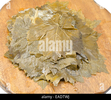 Feuilles de vigne au vinaigre sur planche à découper en bois close up Banque D'Images