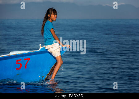 Fille assise sur le petit bateau de pêche, la Baie de Lovina, Bali, Indonésie Banque D'Images