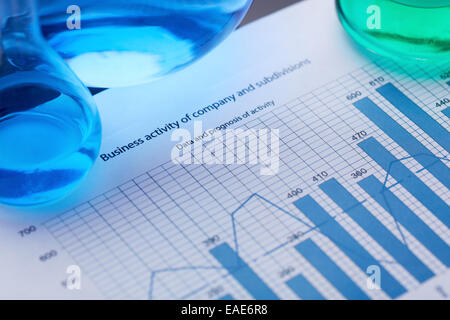 Tubes à essai avec liquides bleu et vert sur le document avec les données financières Banque D'Images