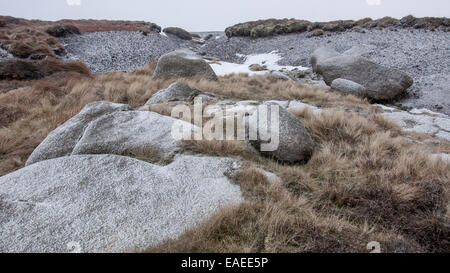 Les affleurements de roches avec des graminées lande couverte dans la première chute de neige sur Kinder scout dans le Peak District, Derbyshire. Banque D'Images