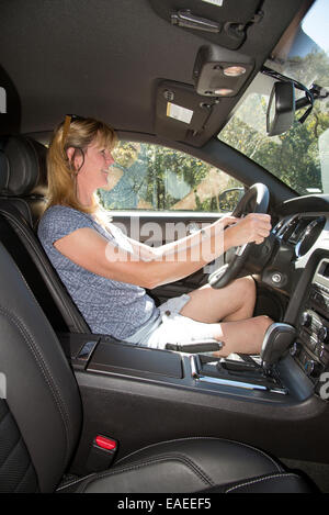 La pilote dans une voiture de sport américaine d'entraînement gauche Banque D'Images