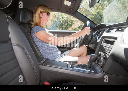 La pilote dans une voiture de sport américaine d'entraînement gauche Banque D'Images