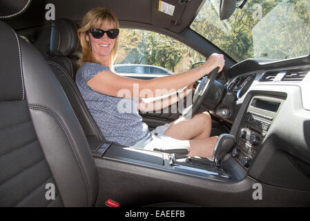 La pilote dans une voiture de sport américaine d'entraînement gauche Banque D'Images