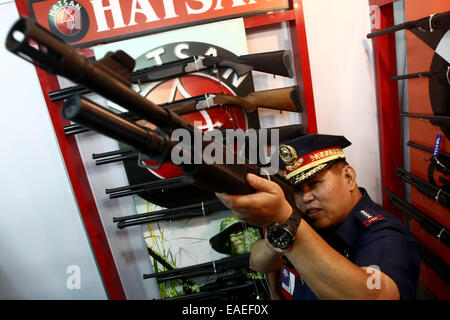 Mandaluyong City, Philippines. 13Th Nov, 2014. La Police nationale générale en chef Alan Purisima tente un fusil affiché à la 22e et la défense armes sportives montrent à Mandaluyong City, Philippines, le 13 novembre, 2014. L'exposition a présenté diverses armes à feu et munitions, visant à promouvoir la propriété d'armes à feu responsables dans le pays. Credit : Rouelle Umali/Xinhua/Alamy Live News Banque D'Images