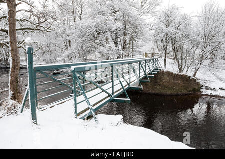 Passerelle sur la rivière Etherow dans des conditions enneigées. Arbres couverts de neige. Prise près du village de Broadbottom à Tameside, en Angleterre. Banque D'Images