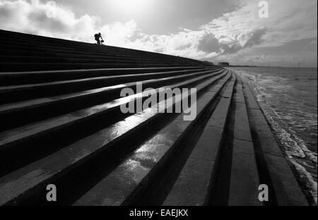 Cycliste sur le seawall à Heacham, Norfolk, Angleterre, Royaume-Uni. Banque D'Images