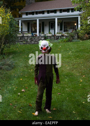 Garçon en costume Halloween et masque sur la pelouse en face de la maison Banque D'Images
