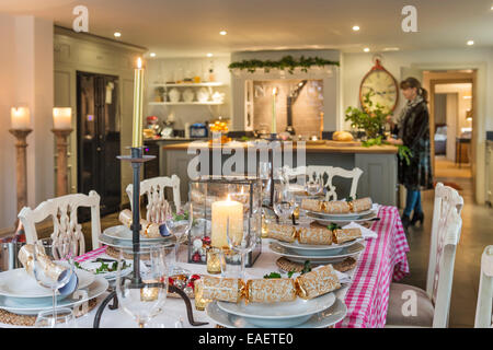 Déjeuner de Noël posé sur table avec des bougies et des craquelins. Dans l'arrière-plan est un plan ouvert cuisine style conçu par Stephanie E Banque D'Images