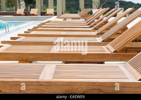 Piscine avec chaises longues en bois. Banque D'Images