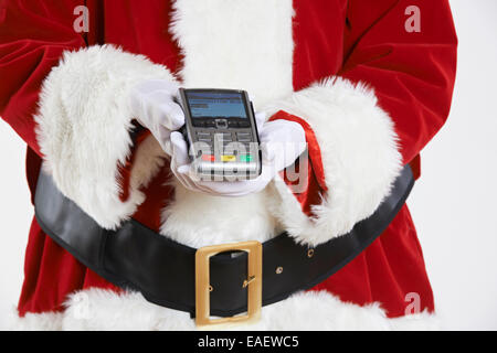 Close Up of Santa Claus Holding Credit Card Reader Banque D'Images