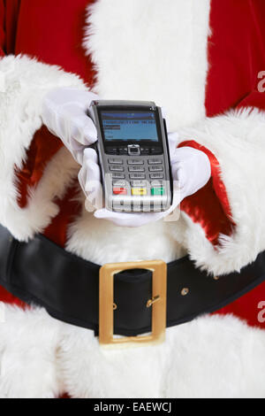 Close Up of Santa Claus Holding Credit Card Reader Banque D'Images