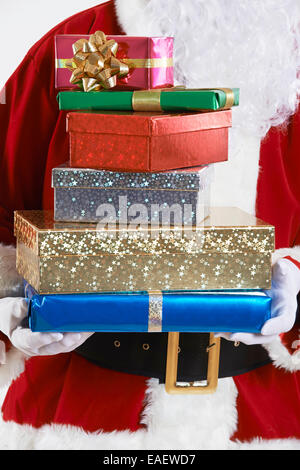 Close Up of Santa Claus Holding Pile of Gift Wrapped Presents Banque D'Images