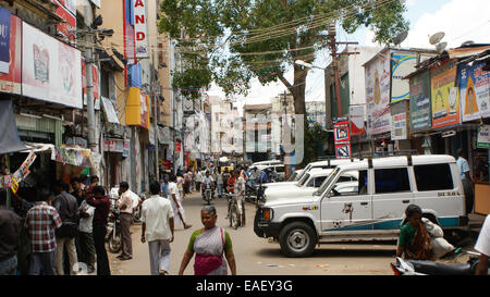 Une rue animée de Madurai en Inde, avec des gens, les motocyclettes et les fourgonnettes. Banque D'Images