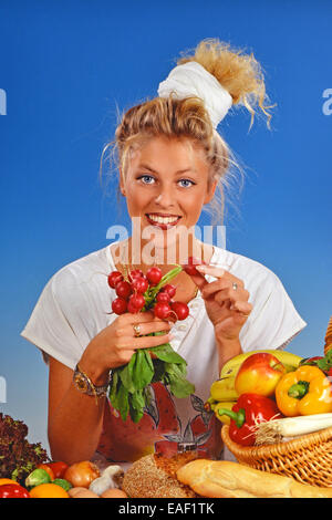 Femme blonde radis manger pour le petit déjeuner Banque D'Images