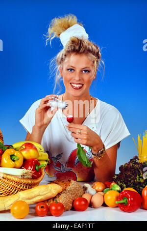 Femme blonde avec des radis manger pour le petit déjeuner Banque D'Images